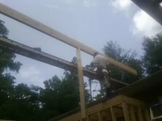 Carpenter setting a ridge beam over a new addition frame — Ice Dam Removal by Roofing Brothers in Middlebury