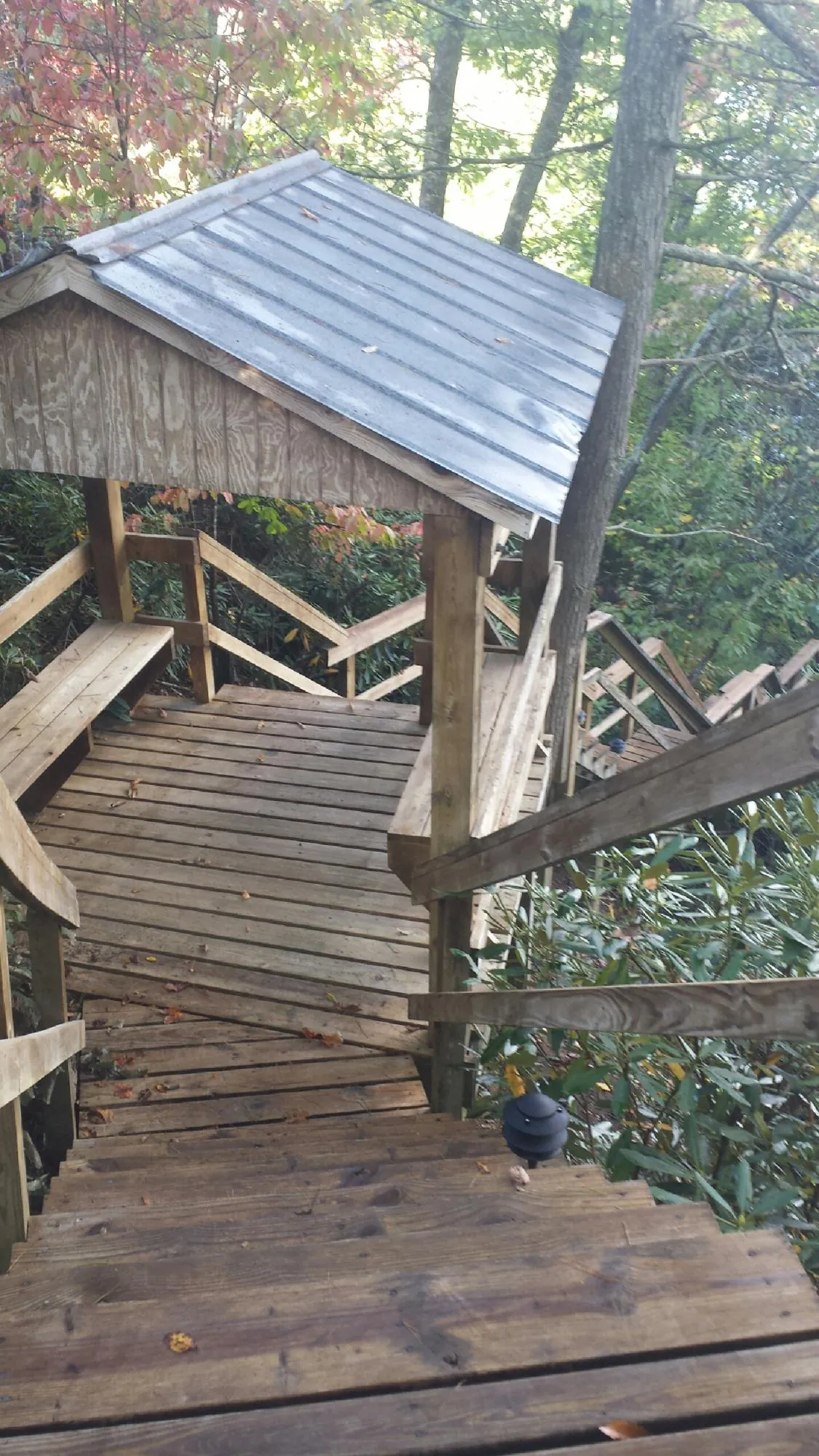 Metal roofed shelter over wooden steps on a wooded walkway — Skylight Repair & Installation work by our crew in Middlebury
