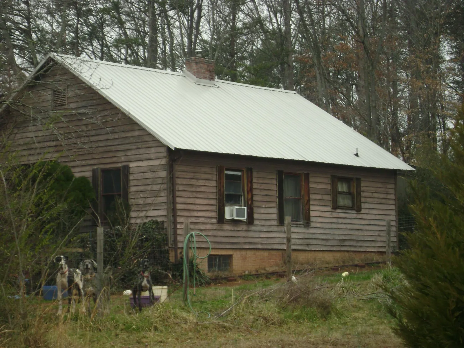 White metal roof on an old wood sided farmhouse, from a Metal Roof Installation job in Middlebury